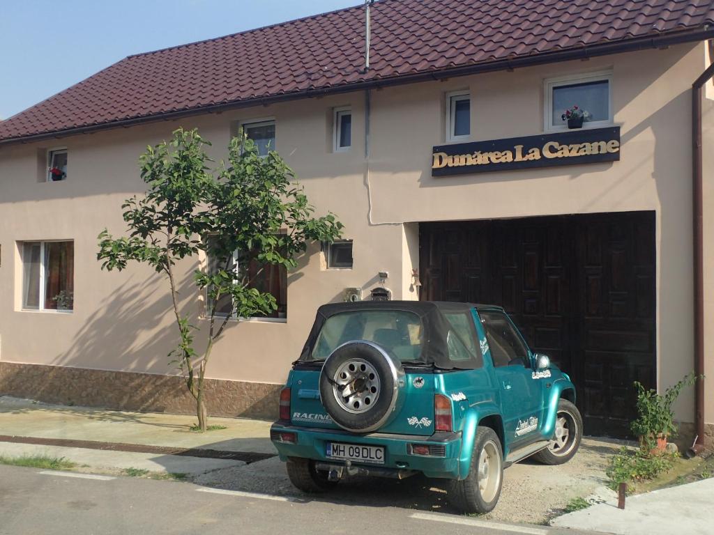 a blue jeep parked in front of a garage at Casa de Oaspeti Dunarea la Cazane in Dubova