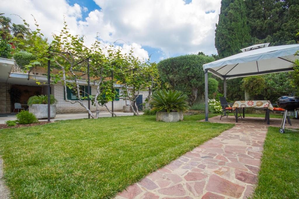 a garden with a table and an umbrella at Apartments Kolenc in Portorož