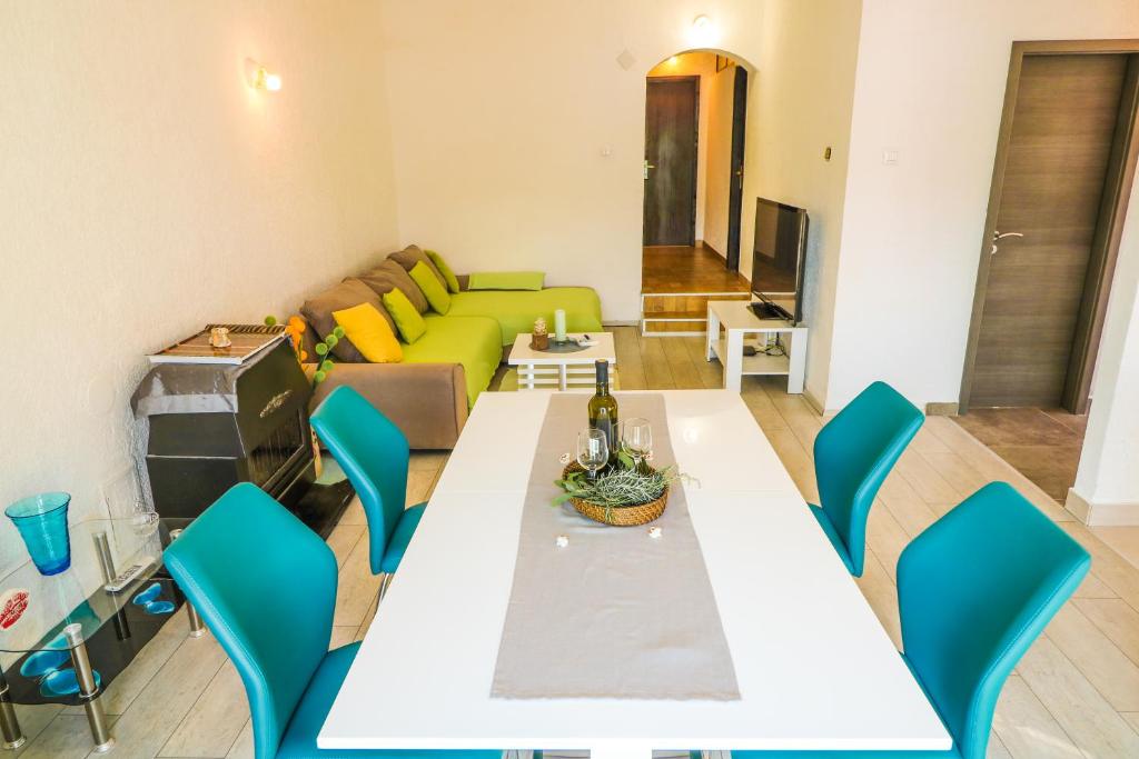 a living room with a table and chairs and a couch at Apartments Andrea in Baška