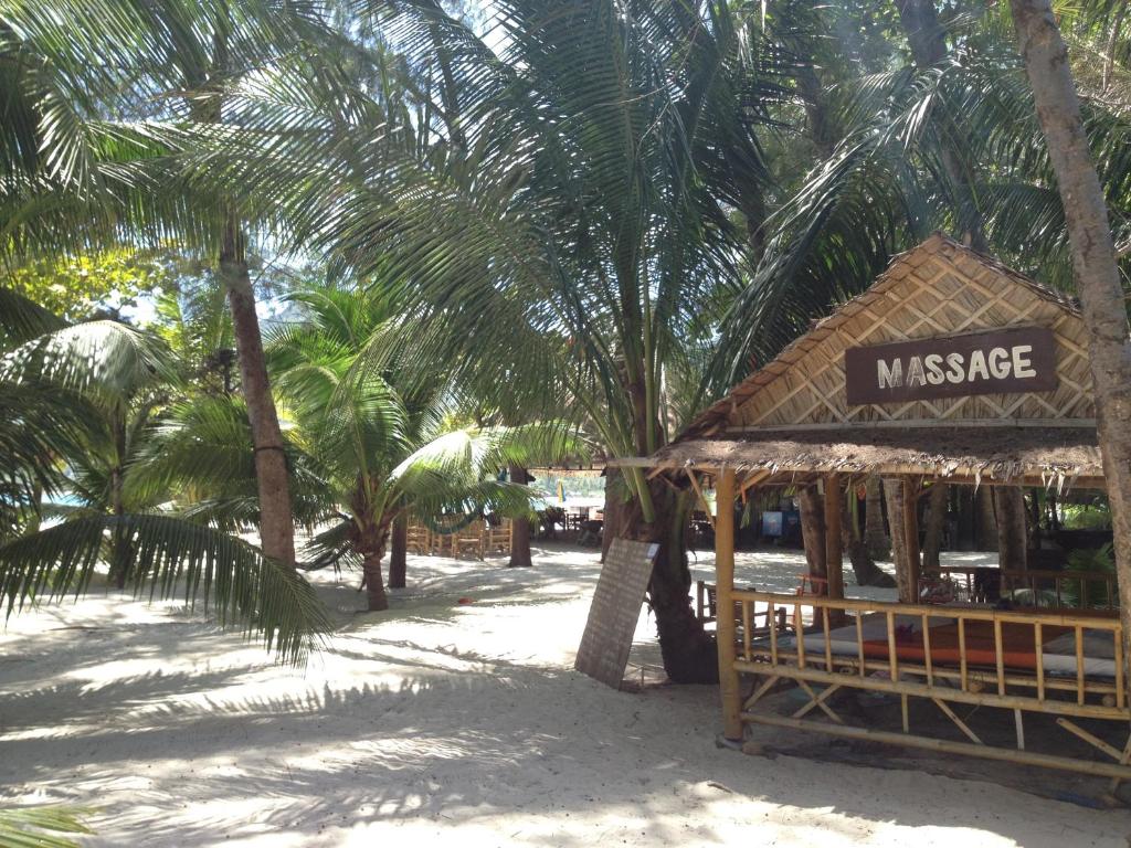 a small building on the beach with palm trees at Malibu Beach Bungalows in Chaloklum
