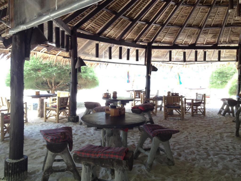 a restaurant with a table and chairs in a pavilion at Malibu Beach Bungalows in Chaloklum