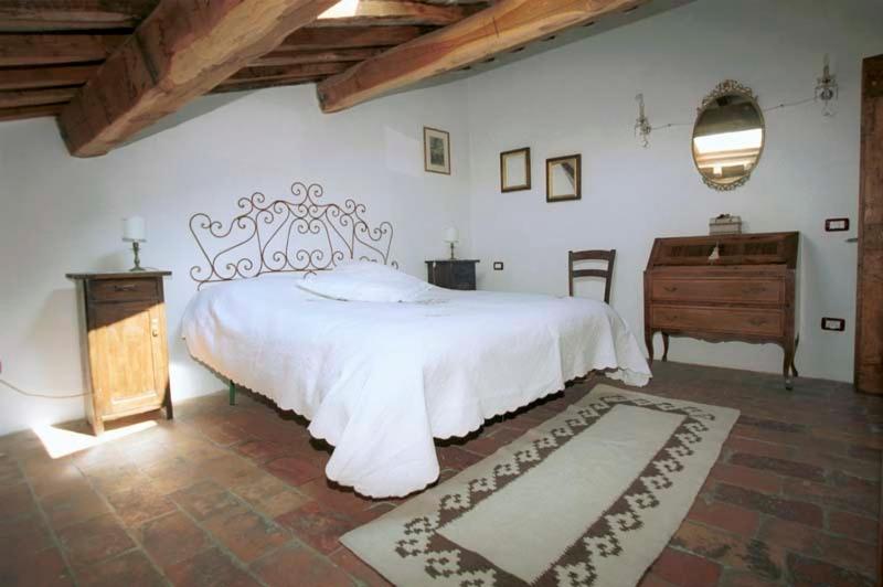 1 dormitorio con cama blanca y tocador de madera en Palazzo San Florido, en Città di Castello