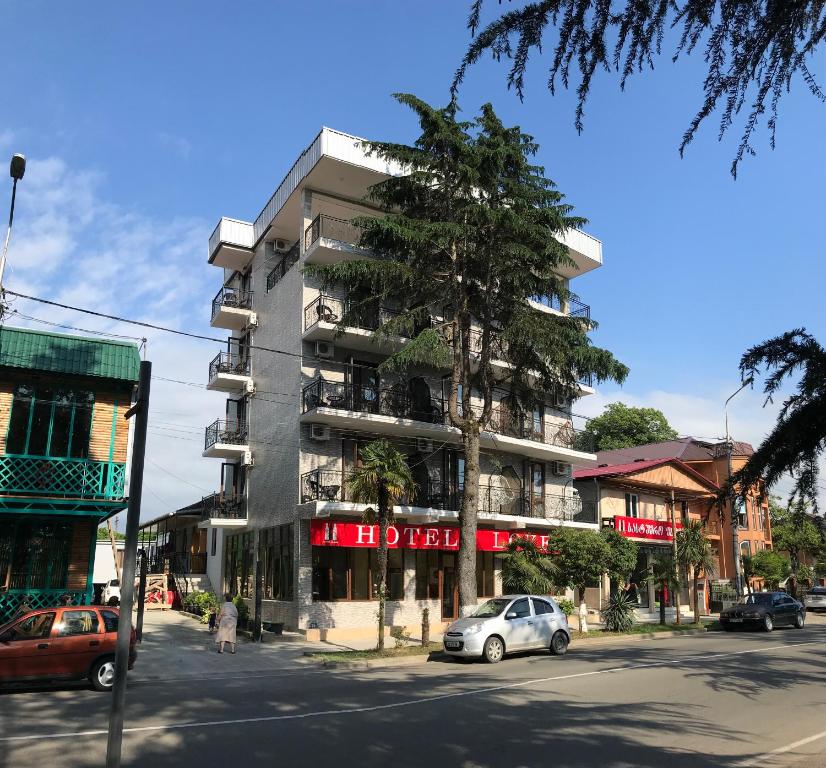 um edifício numa rua com carros estacionados em frente em Hotel Love em Kobuleti