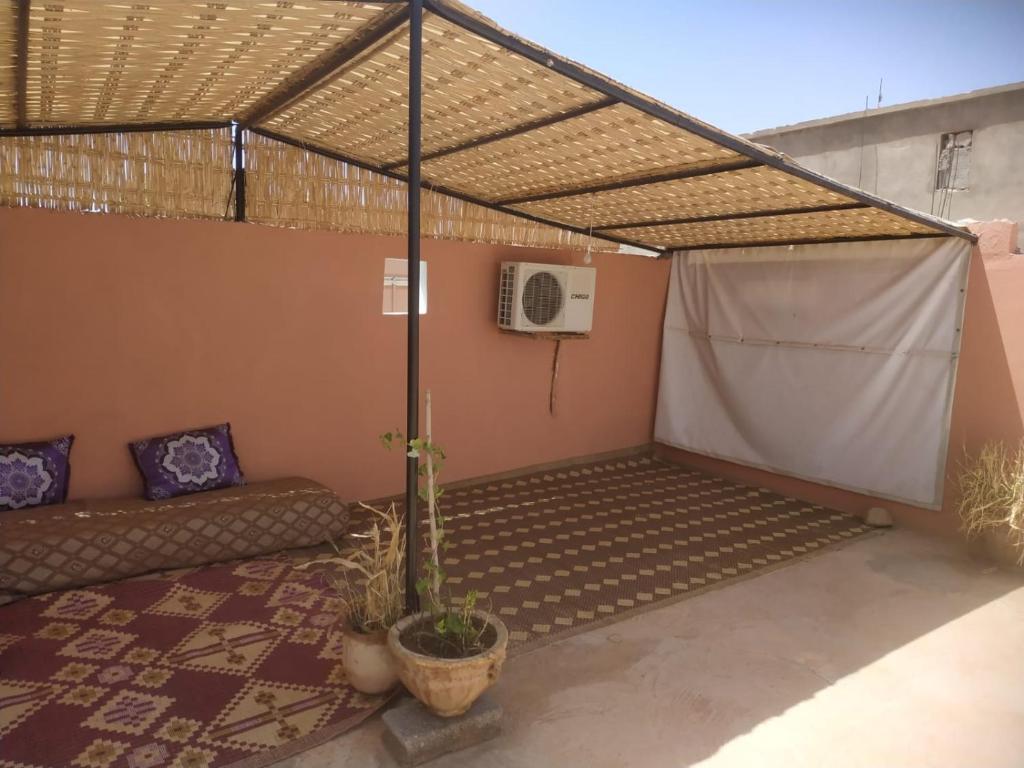 uma pérgola com um sofá e uma mesa em Chez l'habitant (Ba Omar) em Zagora