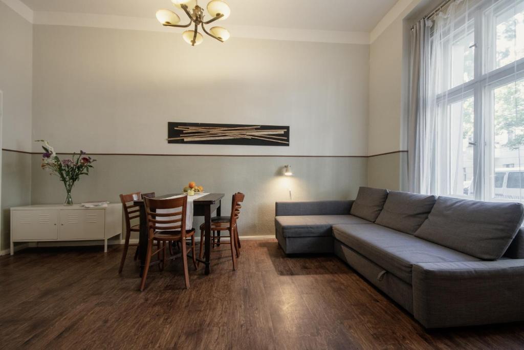 Wohnung mit 2 Bädern (PB3) في برلين: غرفة معيشة مع أريكة وطاولة