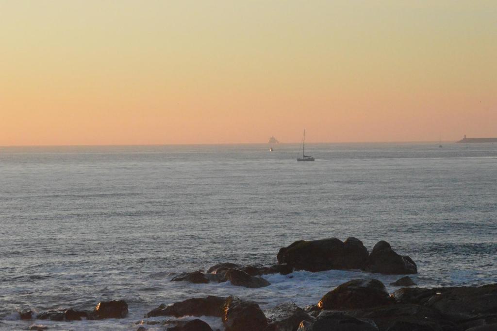 una barca a vela nell'oceano al tramonto di Pôr do Sol a Vila Nova de Gaia