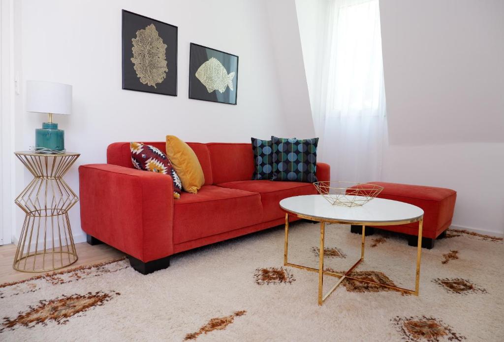 a living room with a red couch and a table at Apartment Zentral in Tübingen