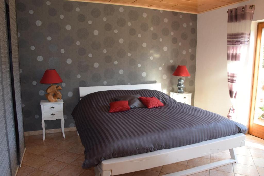 a bedroom with a bed and two tables with lamps at L'Ours Vert in Baerenthal