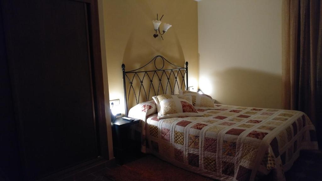1 dormitorio con cama con colcha y almohadas en 75 Avenida de la Rioja, en San Vicente de la Sonsierra