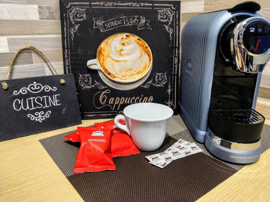 a cup of coffee on a table next to a coffeemaker at B&B L'Edera di Caterina in Reggio di Calabria