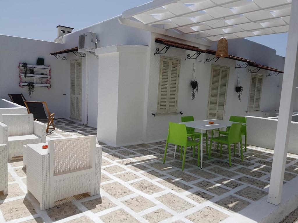 a patio with green chairs and a table on a building at Residence Orsa Minore in Gallipoli