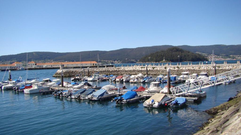 a group of boats docked at a dock in the water at ZONA DE PLAYA in Marín