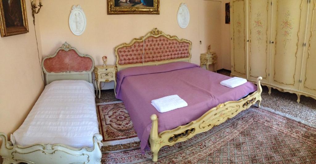 sypialnia z 2 łóżkami i fioletową pościelą w obiekcie Sweet Home New w Wenecji