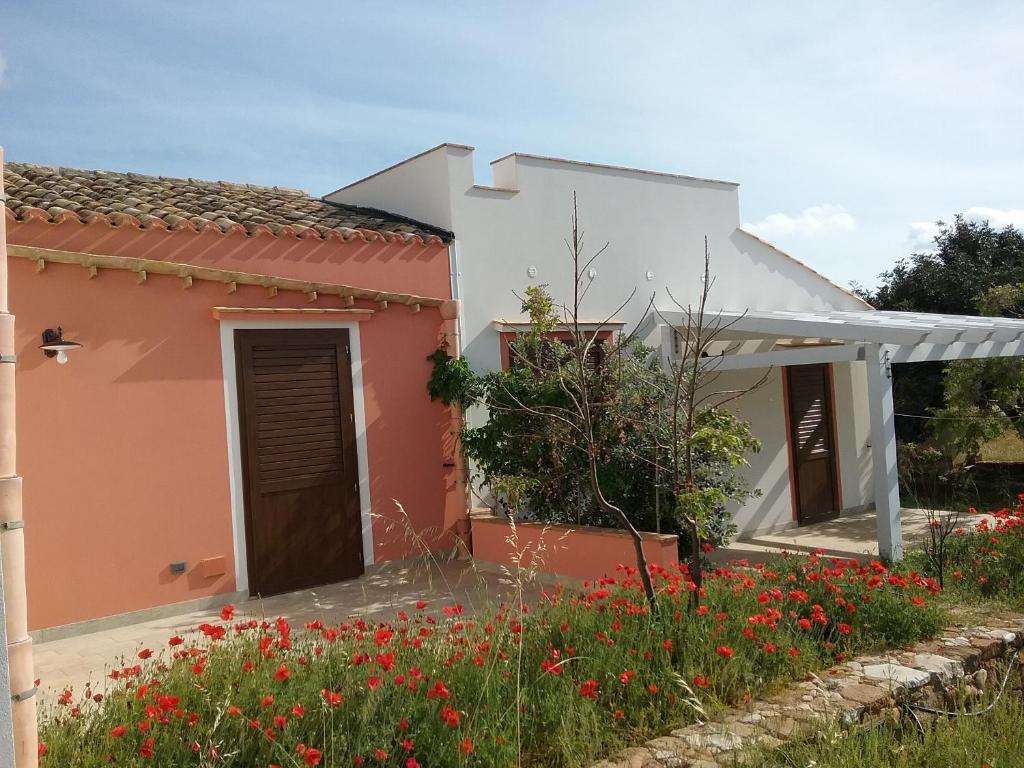 a house with flowers in front of it at Antico Casale sul Mare in Custonaci