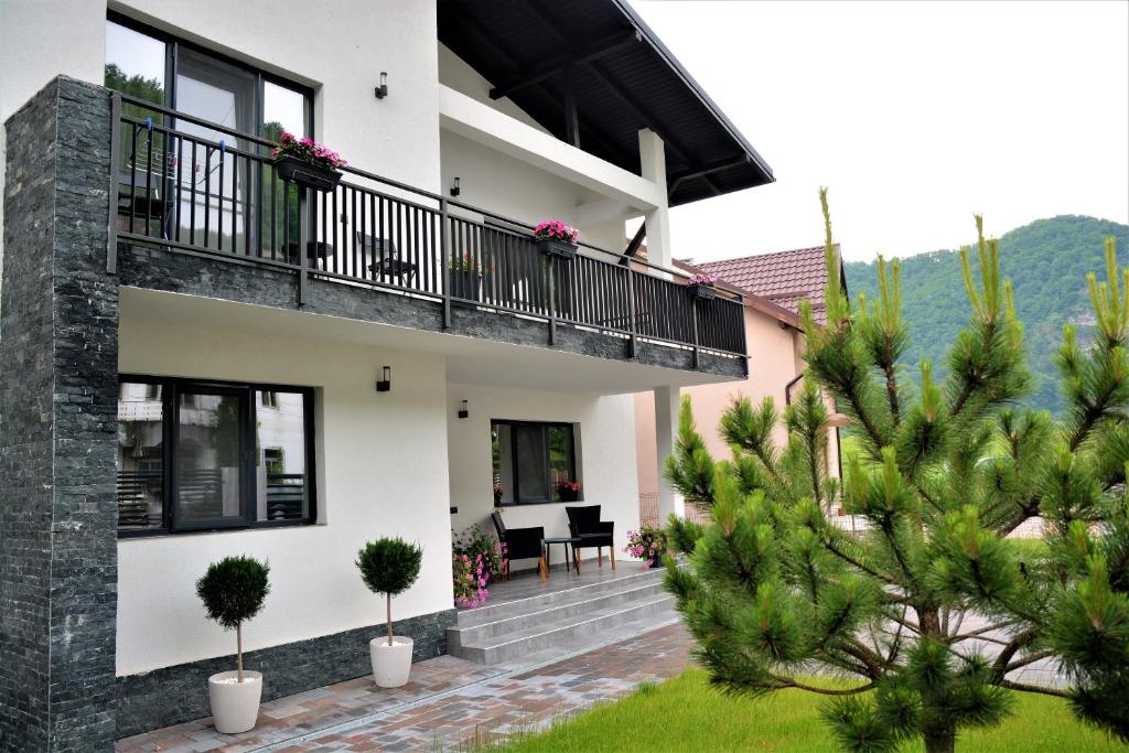 une maison avec un balcon et un jardin dans l'établissement Casa AQUARIUS, à Căciulata