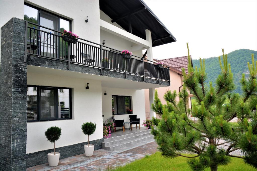 a house with a balcony and a garden at Casa AQUARIUS in Caciulata