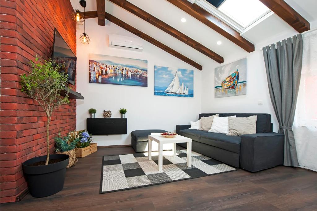 a living room with a couch and a brick wall at The Attic Rovinj in Rovinj