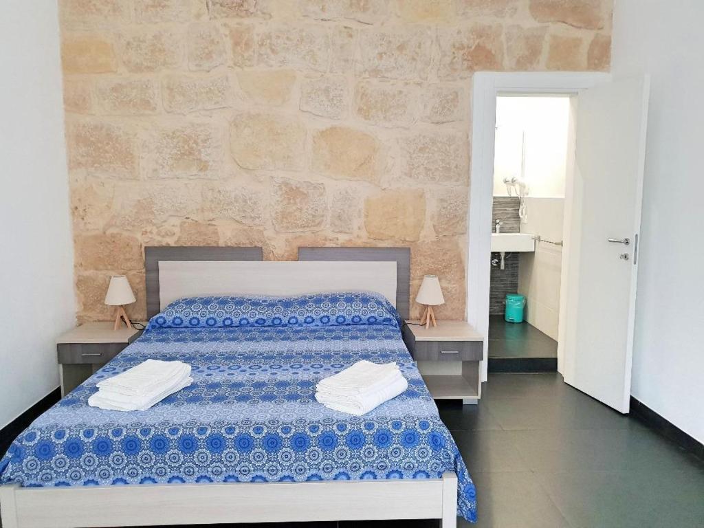 1 dormitorio con 1 cama y 2 mesas con toallas en Blu Maris Acqua, en Marina di Ragusa