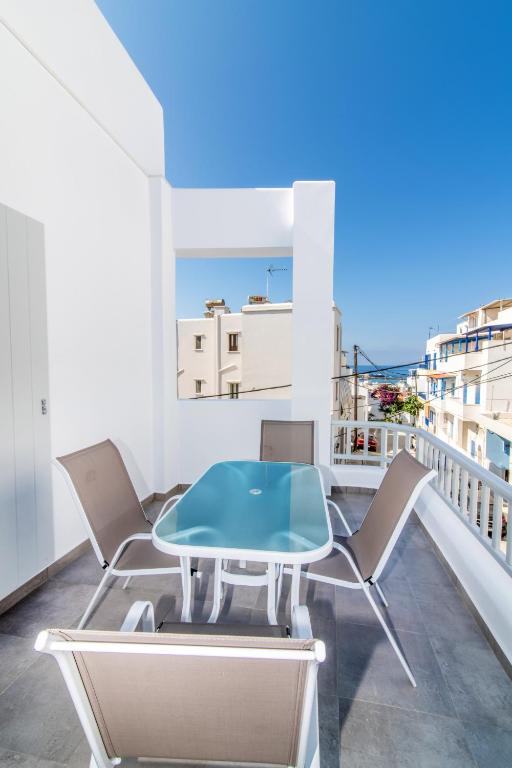 a table and chairs on a balcony with a view at Lux 'n Comfort Apartments in Tinos