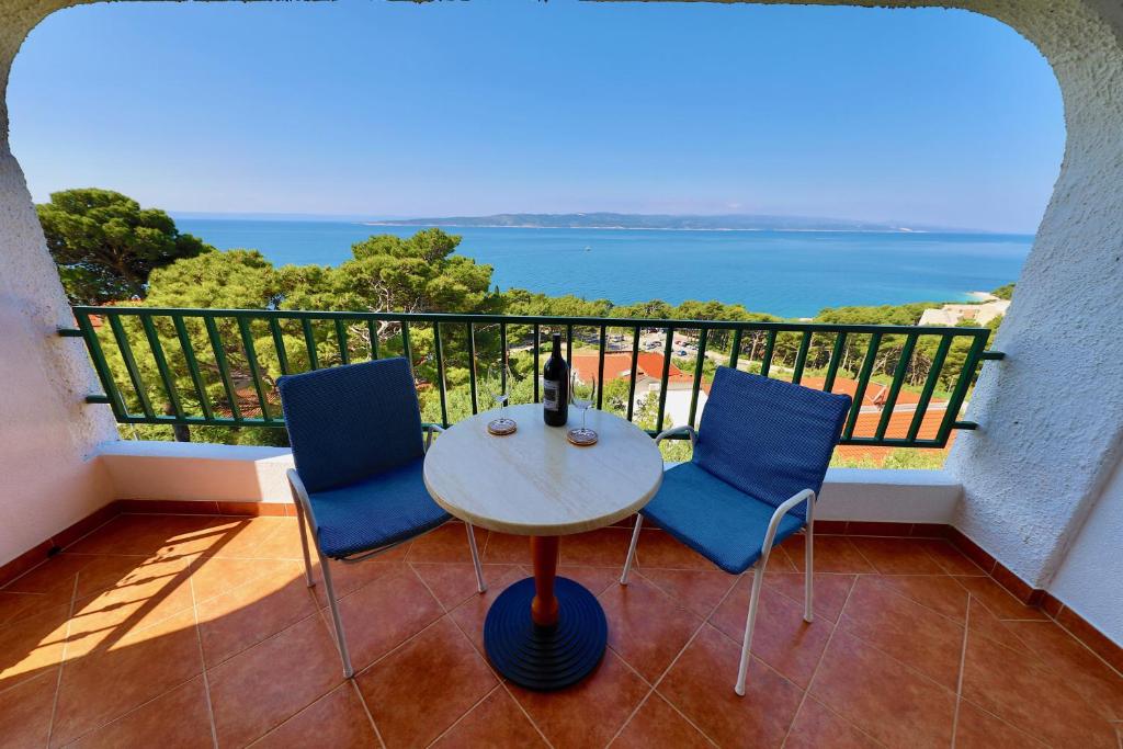 un tavolo e sedie su un balcone con vista sull'oceano di Ribičić Guesthouse a Brela