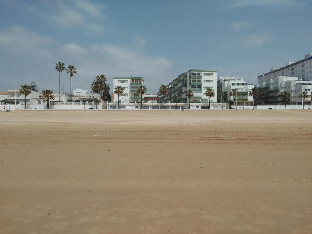 una playa vacía con edificios en el fondo en Frente al mar, en Rota