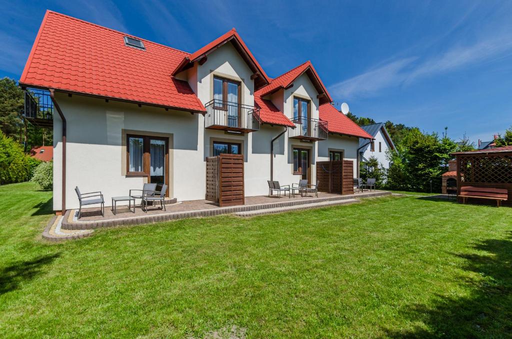 een huis met een rood dak en een tuin bij Zefirek in Dębki