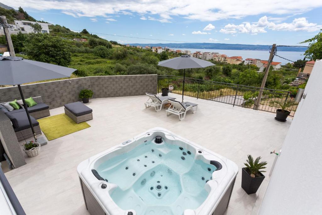 a hot tub on the patio of a house at Apartments Lidija - sea view apartment with exclusive right of using hot tub or split level apartment with exclusive right of using pool in Podstrana