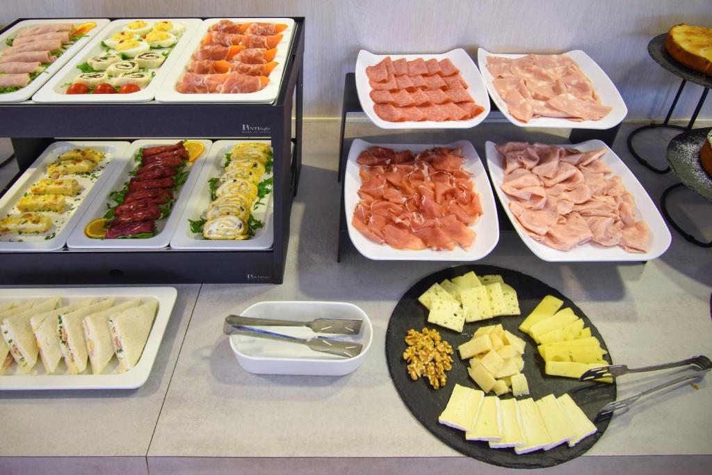 a table with many different types of food in trays at Hotel Lux in Caorle