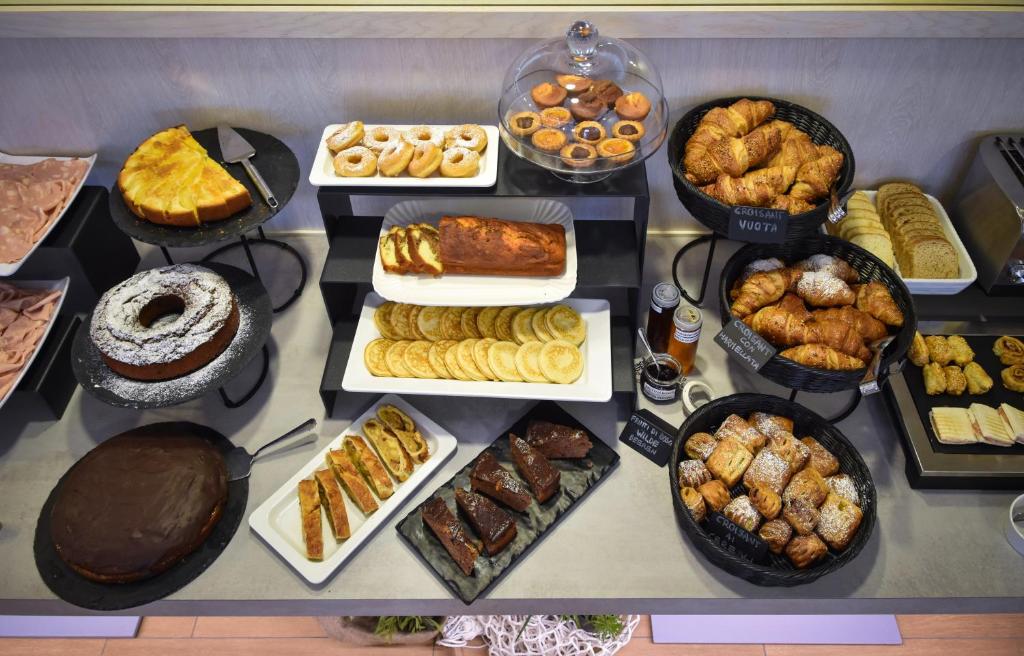 a table filled with different types of pastries and desserts at Hotel Lux in Caorle