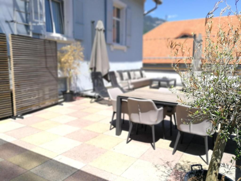 a patio with a table and chairs and an umbrella at Hotel Lötschberg in Interlaken