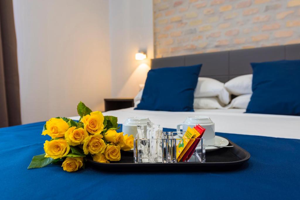 a tray with yellow flowers on a table with a bed at Rent Rooms Trastevere in Rome