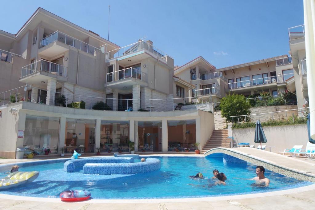 a group of people in a swimming pool in a apartment at Beautiful Sun Village with sea view in Byala