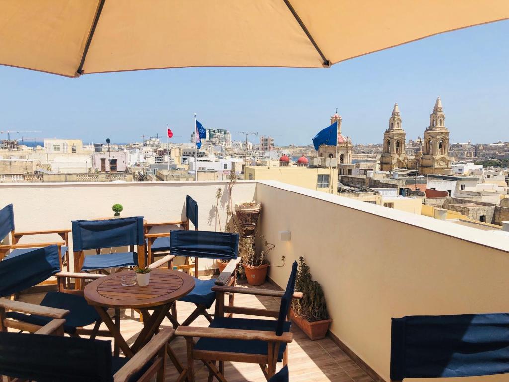 a balcony with chairs and tables and a view of the city at Nautilus Boutique Townhouse in Sliema