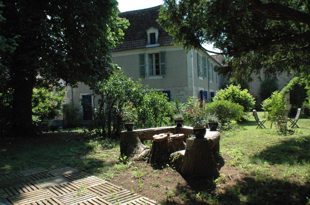 a house with a yard with a tree stump at Le Nid des Oiseaux in Cubjac
