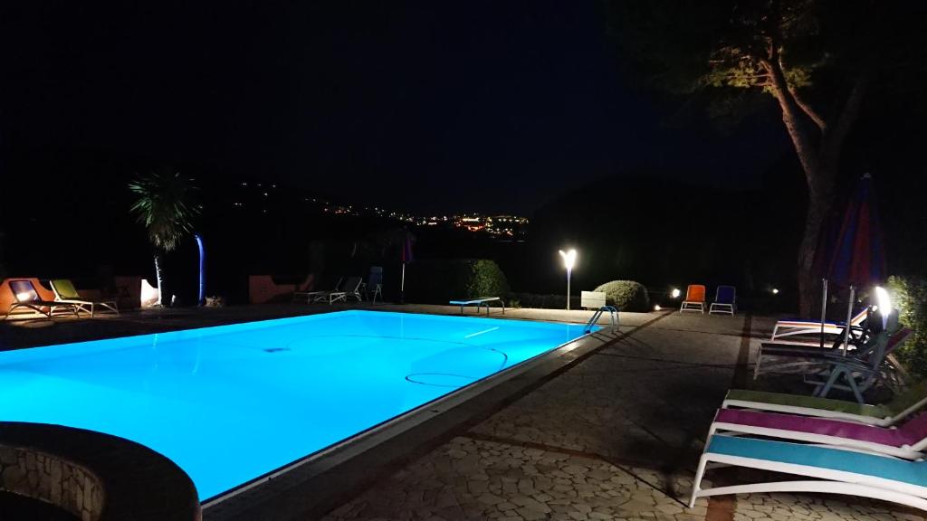 a swimming pool at night with blue lights at Residence Melograno in Capoliveri
