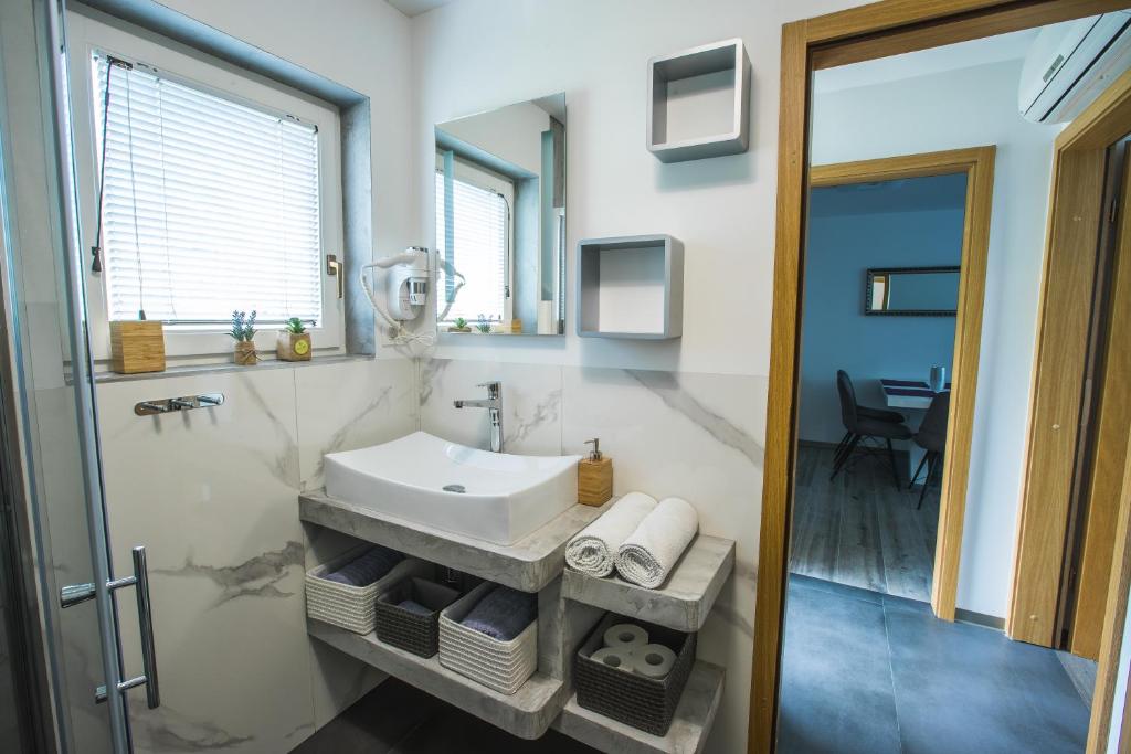 un bagno con un lavandino bianco e uno specchio di Apartment Ma&Ja with Hot Tub a Metlika