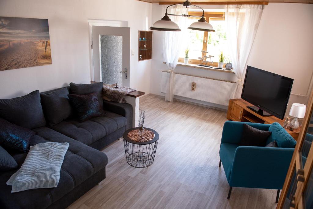 a living room with a couch and a tv at Wohlfühloase Brombachsee in Pleinfeld