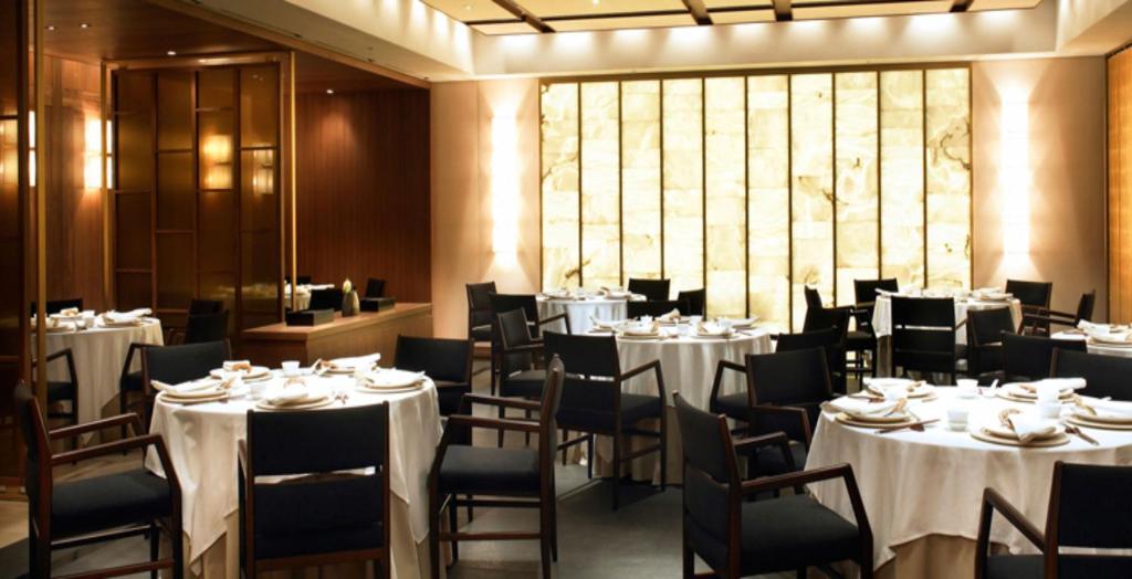 a dining room with white tables and chairs at The Shilla Seoul in Seoul