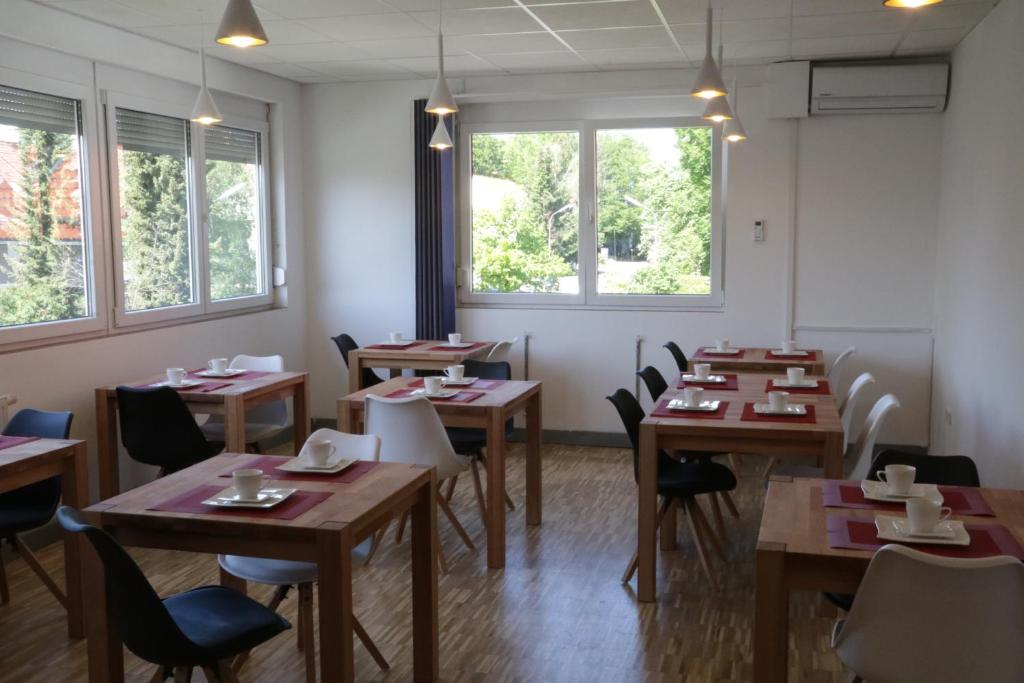 格雷茲里德的住宿－Pension Isartal，用餐室设有桌椅和窗户。