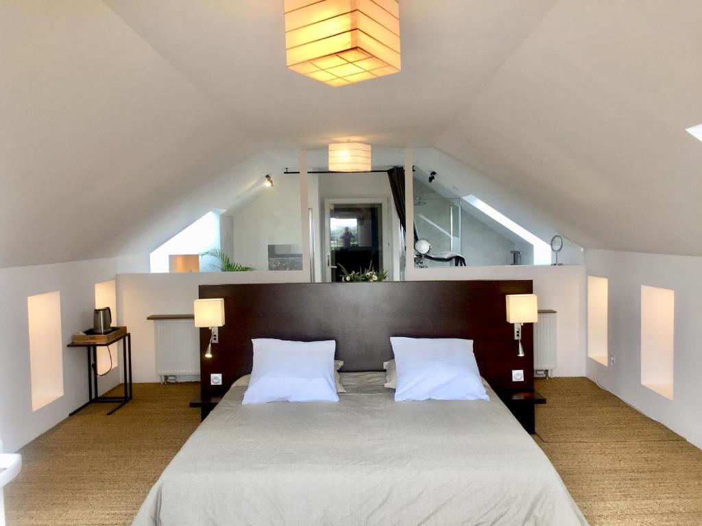 a bedroom with a large bed with two white pillows at Galerie, Tumulus de la Hogue in Fontenay-le-Marmion