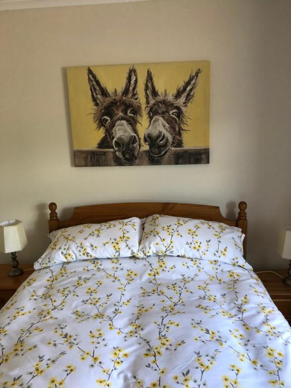 a bedroom with a bed with two donkeys on it at Laurel Country Cottage in Ballymena
