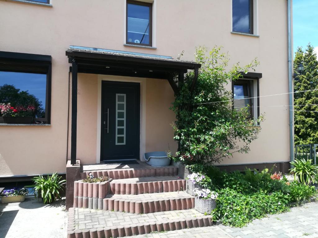 ein Haus mit einer Treppe, die zu einer Tür führt in der Unterkunft Ferienwohnung am Park in Pegau