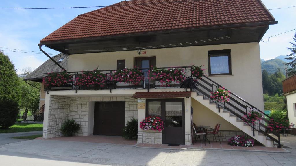 ein Haus mit einem Balkon mit Blumen darauf in der Unterkunft D-D in Bovec