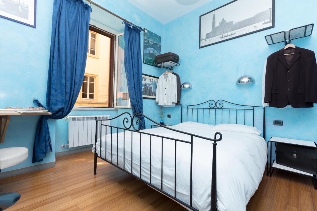 a blue bedroom with a bed and a window at DomusAmor Colosseo in Rome