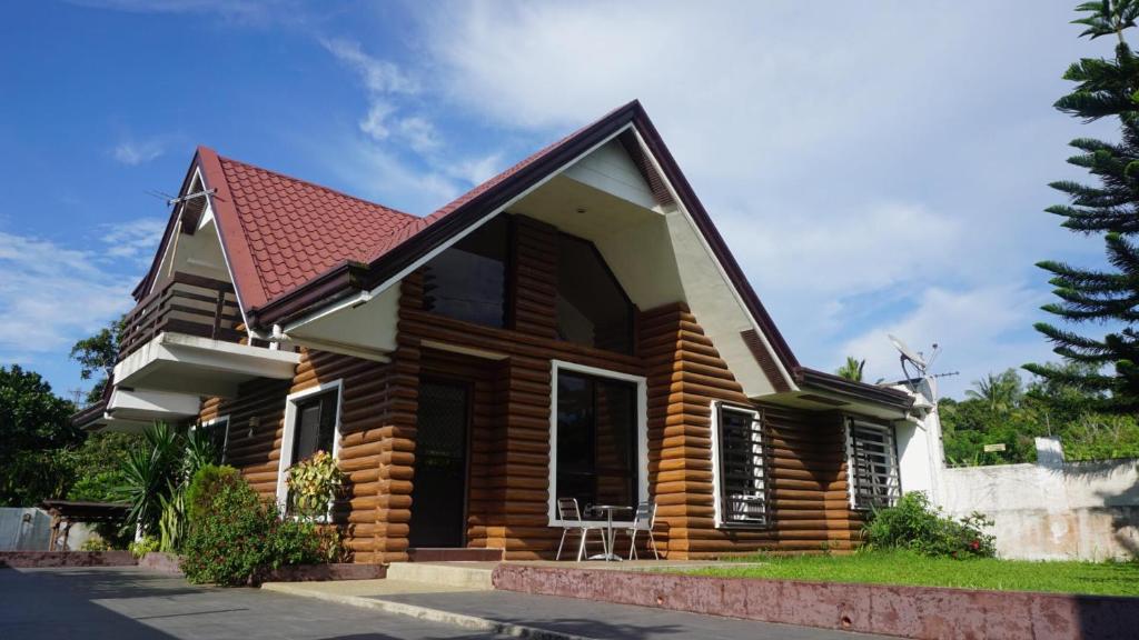 a wooden house with a red roof at MG Holiday Home Tagaytay in Tagaytay