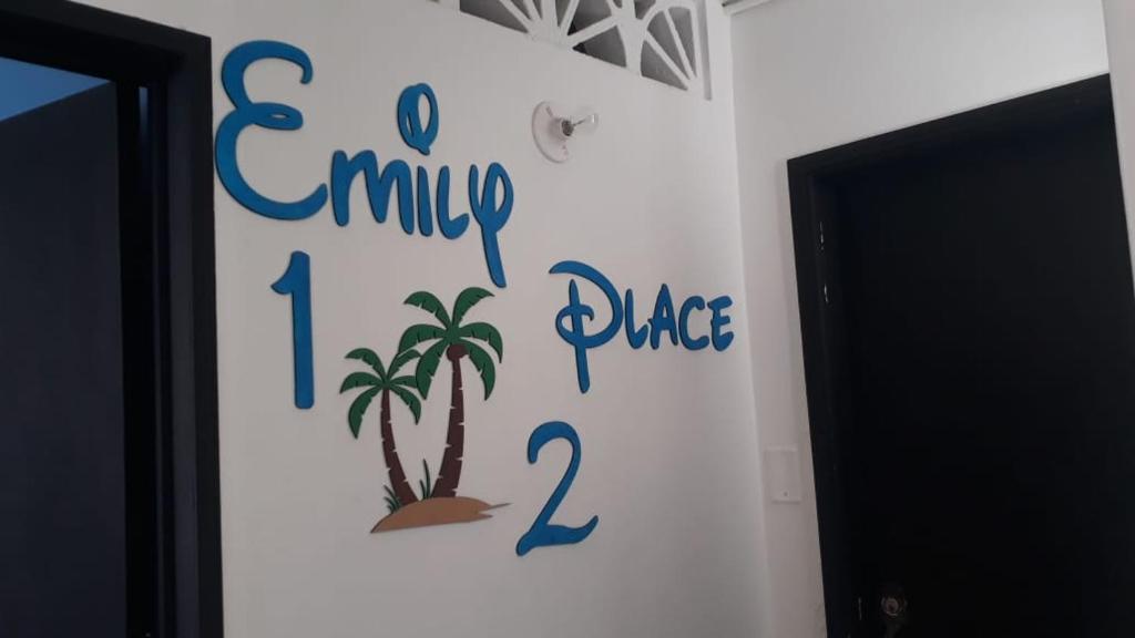 a sign on a wall with a palm tree on it at Emily place 1 y 2 in San Andrés