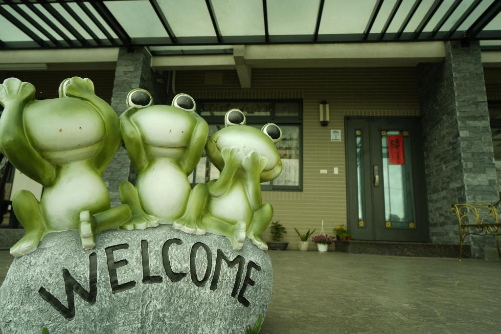 a statue of three frogs sitting on top of a welcome sign at TiAmo B&B Yilan in Dayin