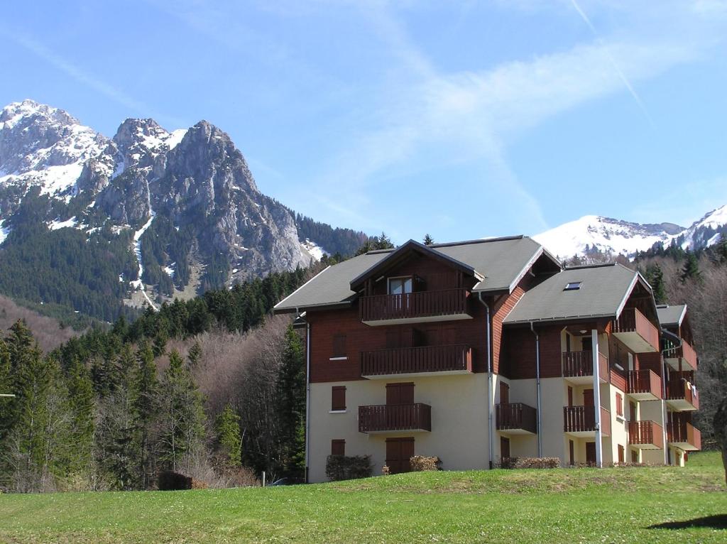 a large building with mountains in the background at Appartement T2 à BERNEX avec WiFi, vue sur montagne in Bernex