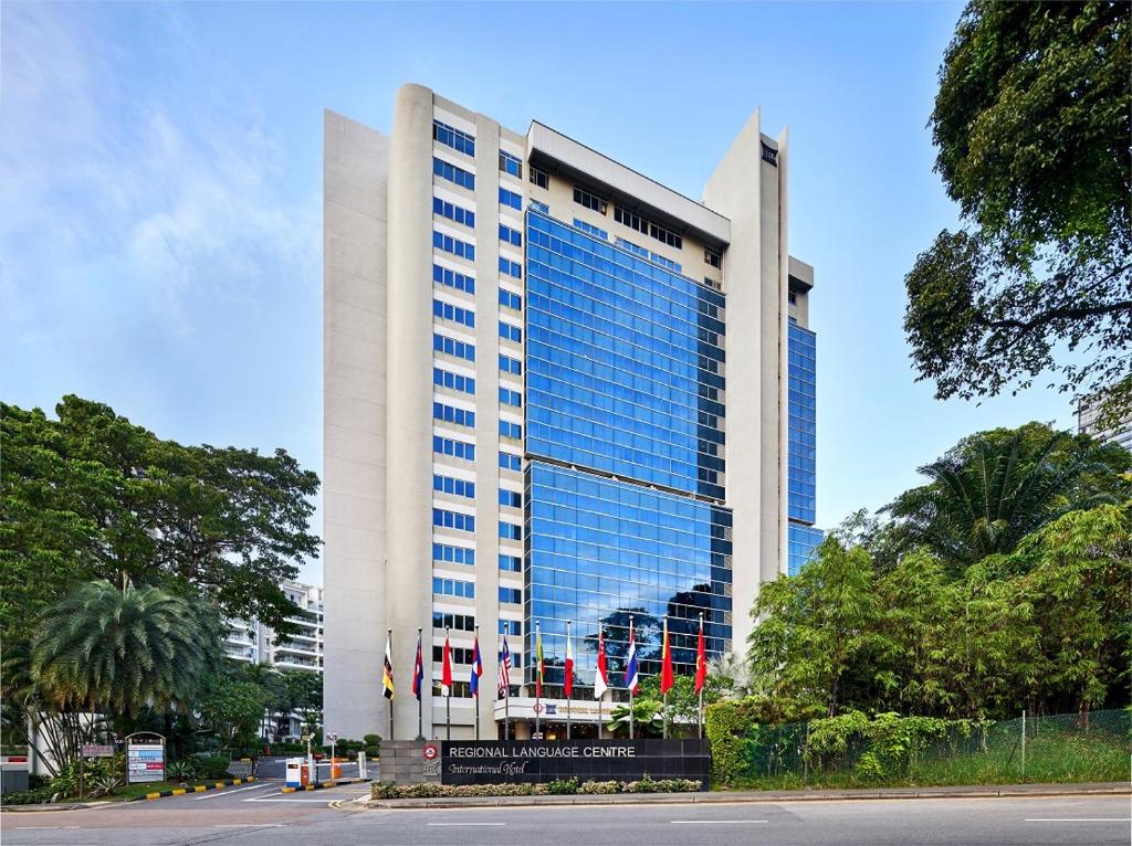 Un palazzo alto con un cartello davanti di RELC International Hotel a Singapore