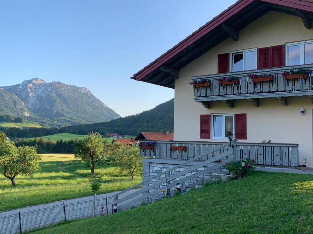 a white house with a balcony and a mountain at Haus Annerl Ferienwohnung mit 2 Schlafzimmern in Inzell